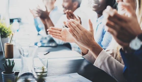 Close up view of business seminar listeners clapping hands.