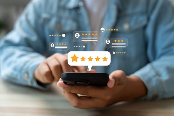 Person leaving a five-star review on a phone, illustrating how customer feedback supports retention marketing strategies