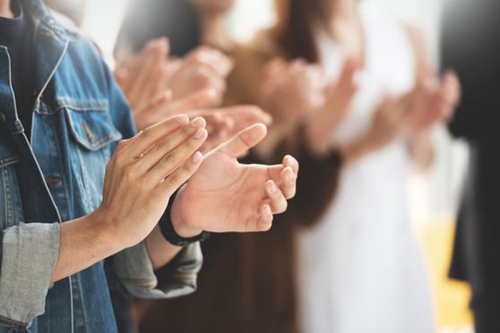 Audience applauding at a seminar.
