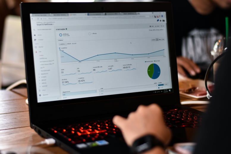 Laptop displaying dashboard with charts and graphs for customer data analytics performance tracking.