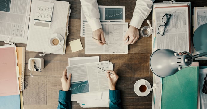 Finance professionals reviewing reports and data for AI-driven decision making.