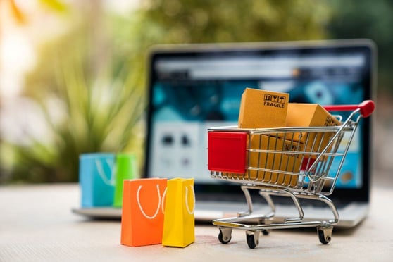 Product package boxes in cart with shopping bag.