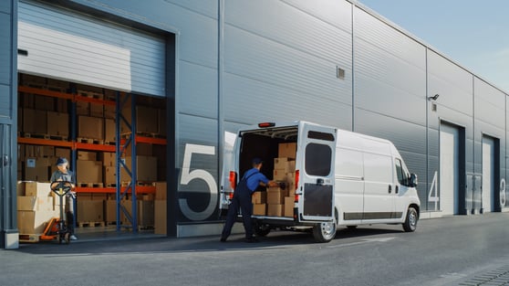 Outside of Logistics Retailer Warehouse With Female Manager Using Tablet Computer, Worker Loading Delivery Truck with Cardboard Boxes