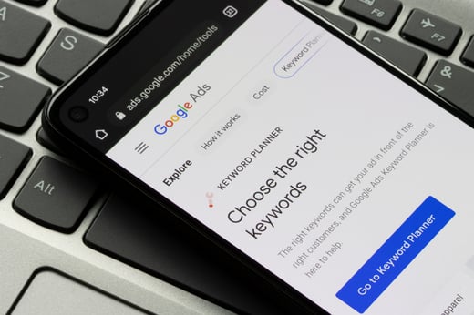 Google Ads Keyword Planner tool on smartphone screen used in paid search tactics to choose the right keywords.