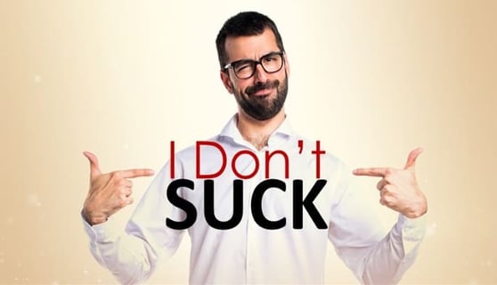 Man pointing to himself with both hands, with the words I Don't Suck on his chest.
