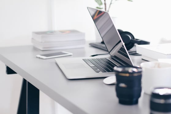 Sleek office setup with laptop and camera lens showing how to use video marketing for content creation.