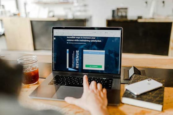 Person analyzing website performance metrics for A/B testing for landing pages on a laptop.