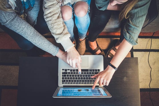 People working on a laptop to plan digital campaigns around the human element in marketing.
