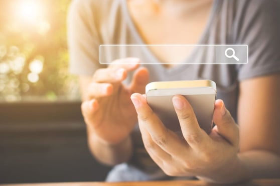 Women using a smartphone with a search bar overlaid, illustrating the importance of zero click searches.